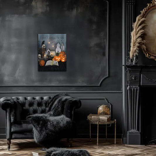 Dark interior with a sofa, table, and wall art featuring pumpkins and an open book.