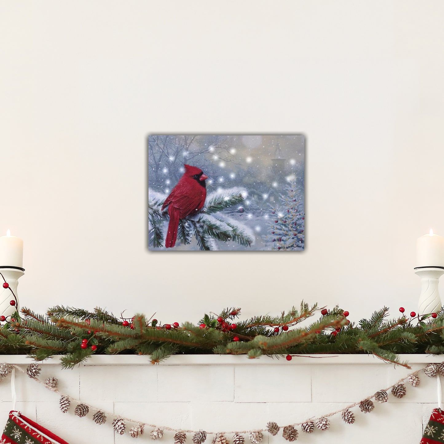 Decorative mantel with a red cardinal canvas print, candles, and Christmas garland.