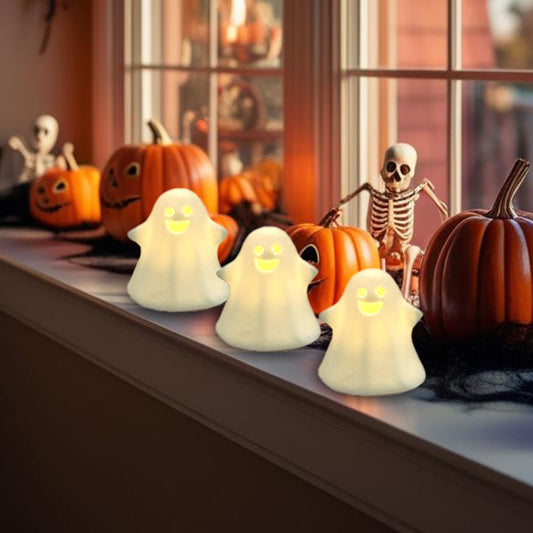Halloween-themed decor with smiling ghost lights, pumpkins, and skeletons on a windowsill.