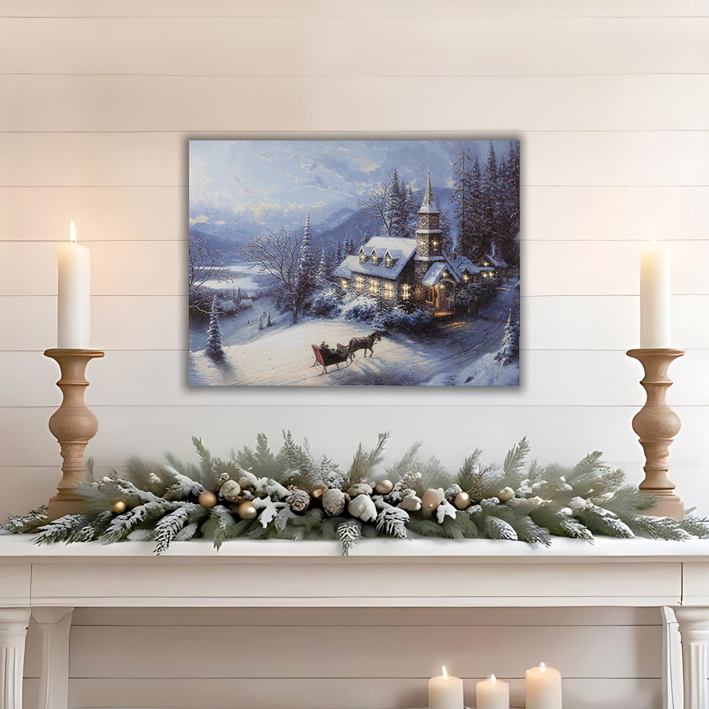 Winter landscape canvas wall art above a decorated mantel with candles and greenery.