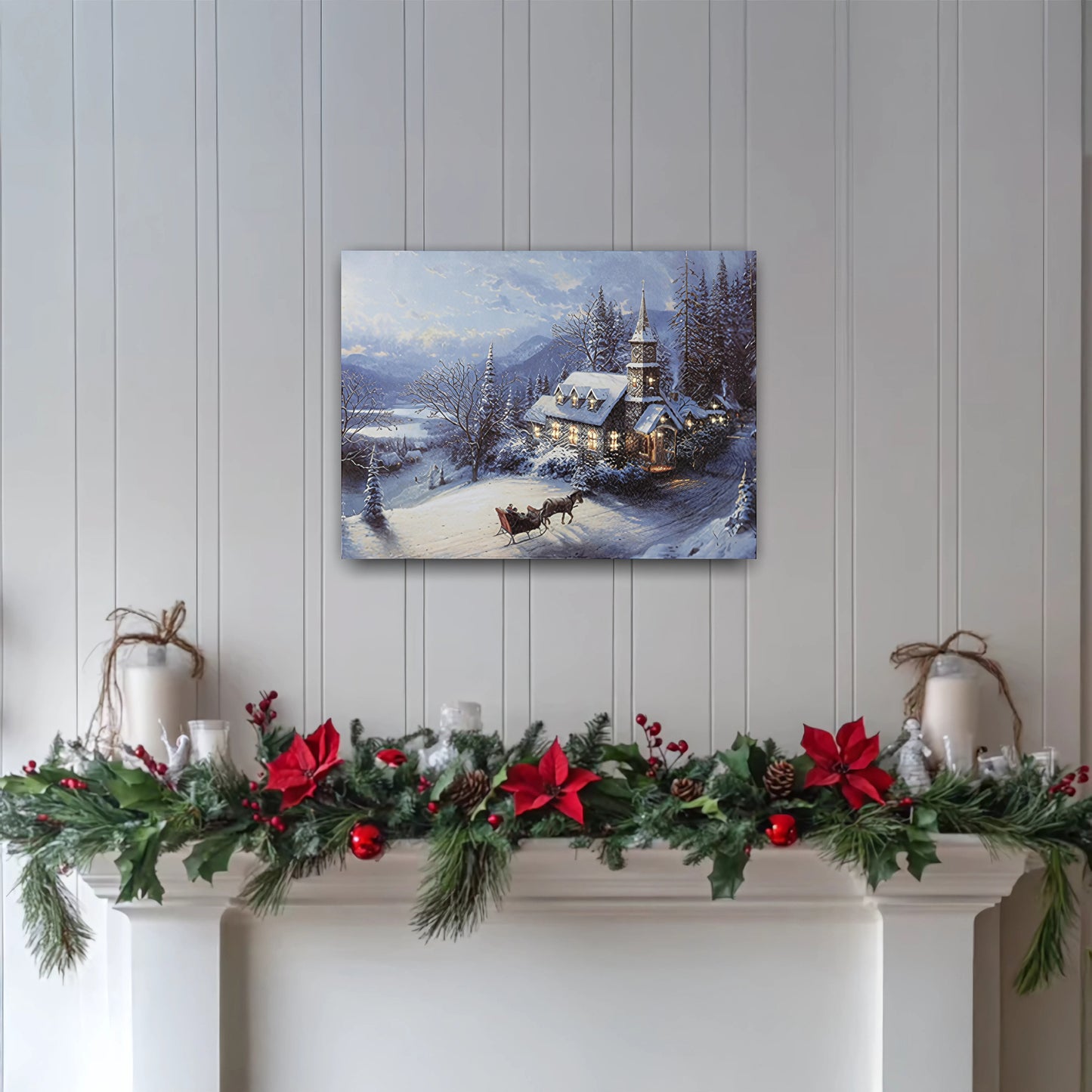 Decorative Christmas mantel with garland and candles, featuring a winter scene print on the wall.