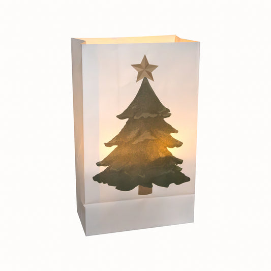 A glowing white paper luminaria bag with a printed design of a Christmas tree and a star at the top.