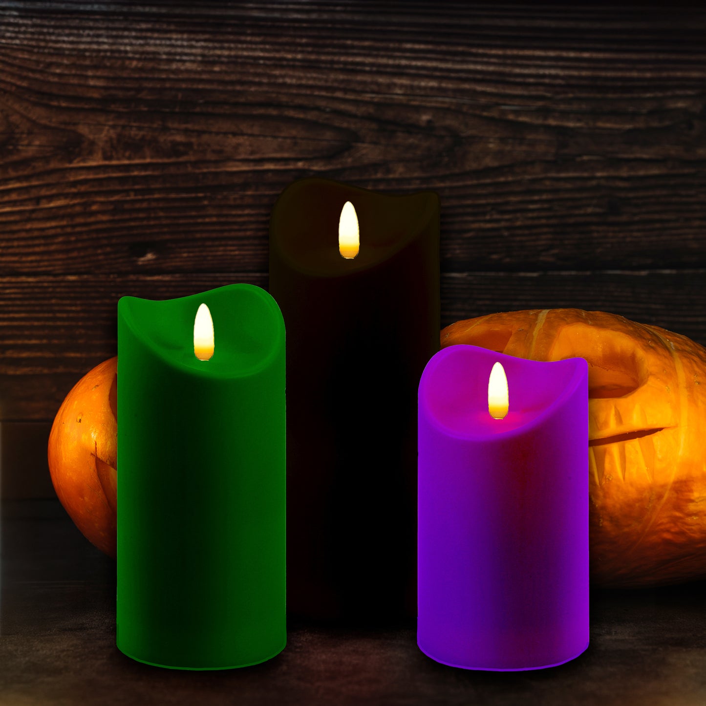 Set of three battery operated pillar candles in black, green and purple with 3D bullet flame and jack-o-lanterns.