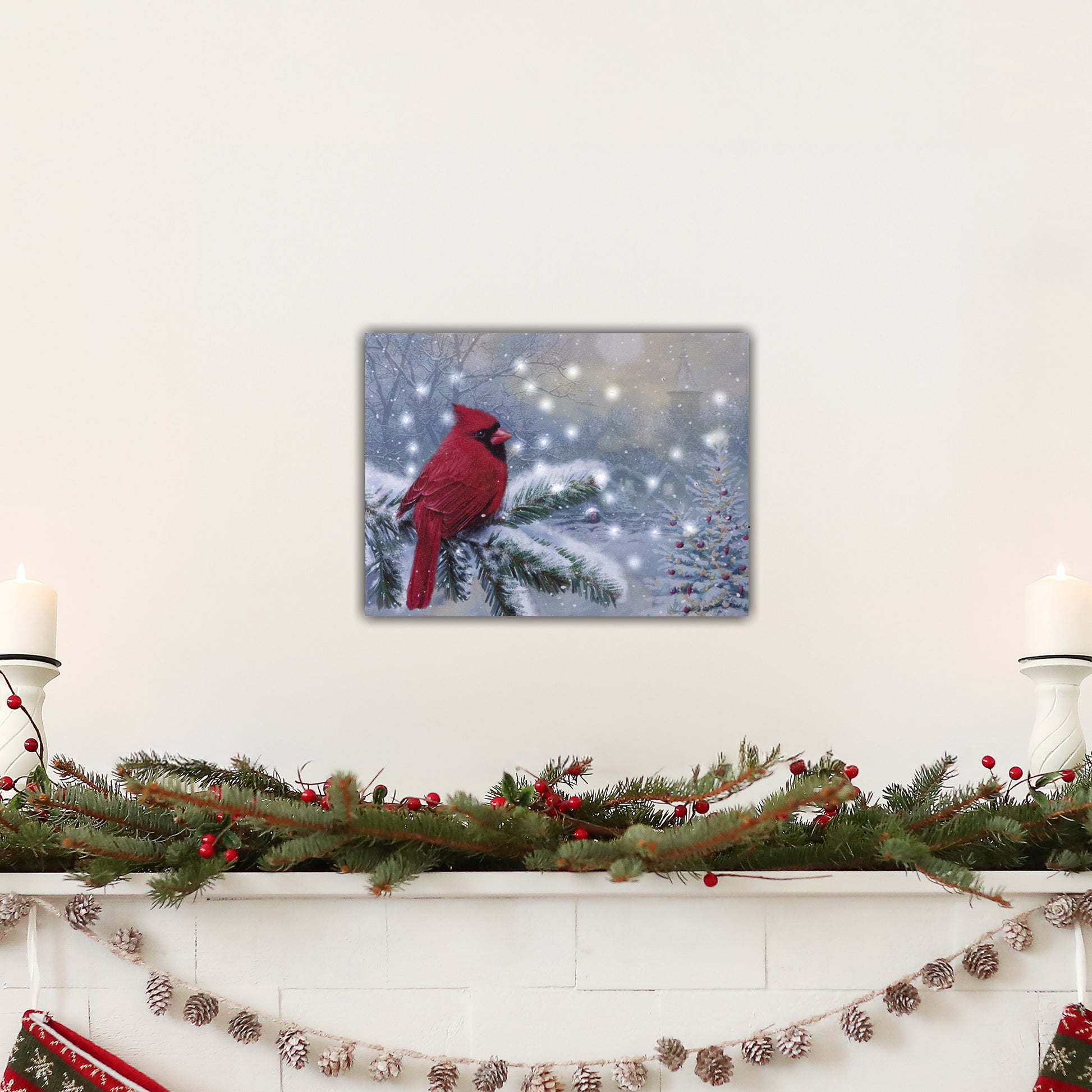Decorative mantel with a red cardinal canvas print, candles, and Christmas garland.