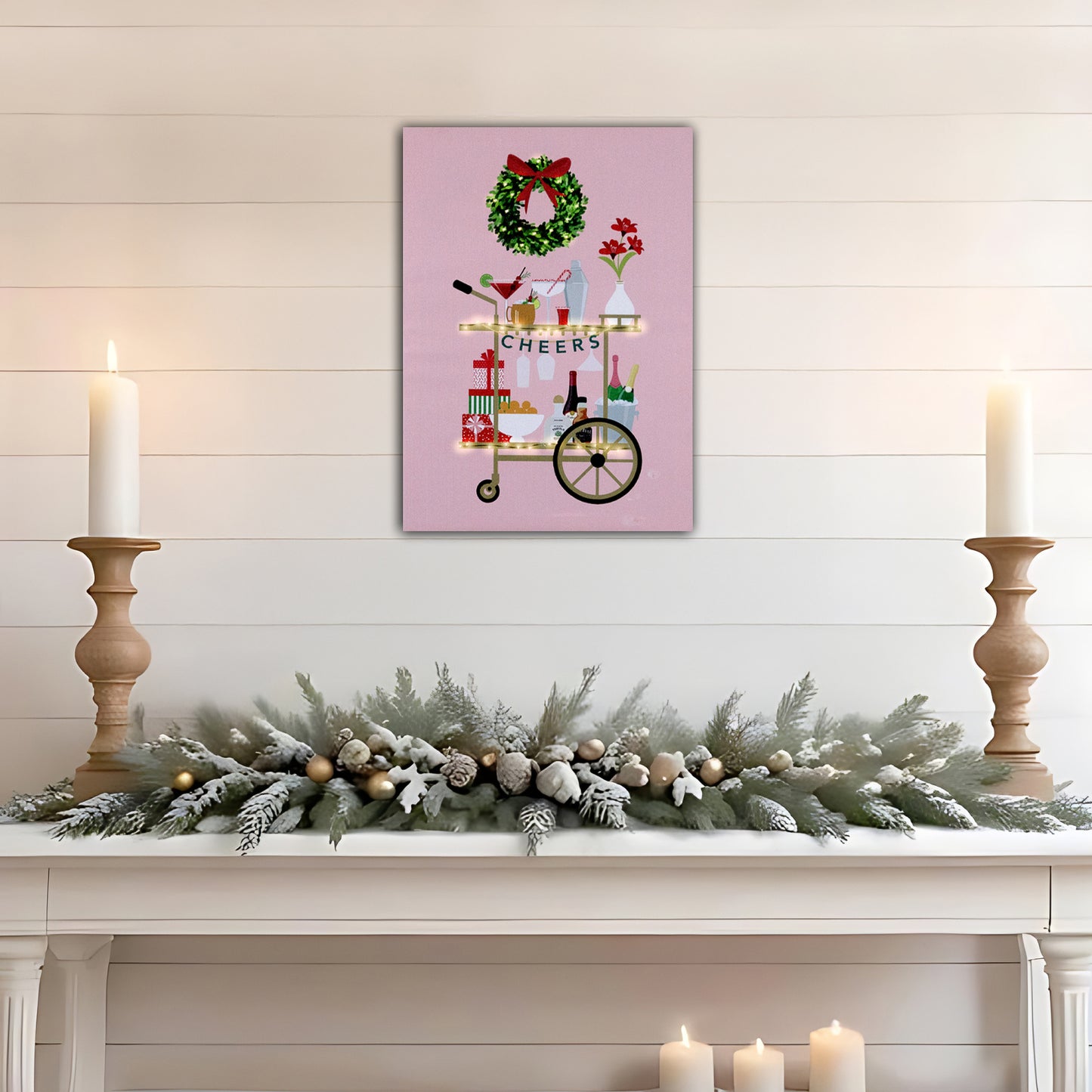 Decorative Christmas mantel with a festive wreath, candles, and a cart illustration on a pink background.