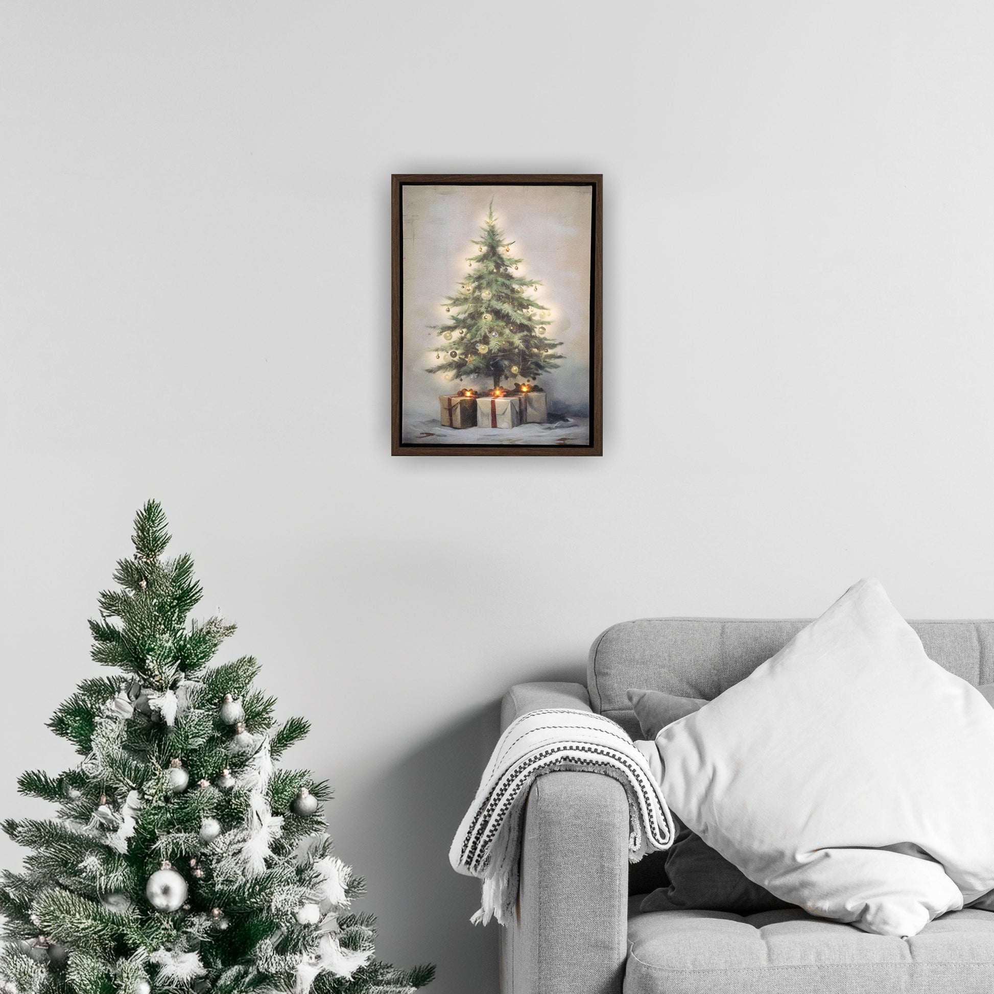 Framed artwork of a Christmas tree on a wall above a decorated tree and sofa.