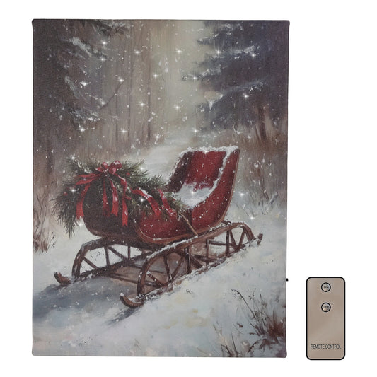 A canvas wall art featuring a red sleigh with a bow in a snowy forest setting, illuminated by battery-operated cool white LED lights, accompanied by a remote control.