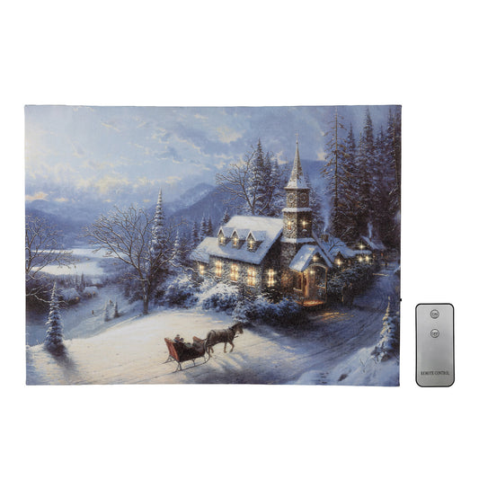Canvas wall art winter scene with a church and sleigh, featuring a remote control on a white background.