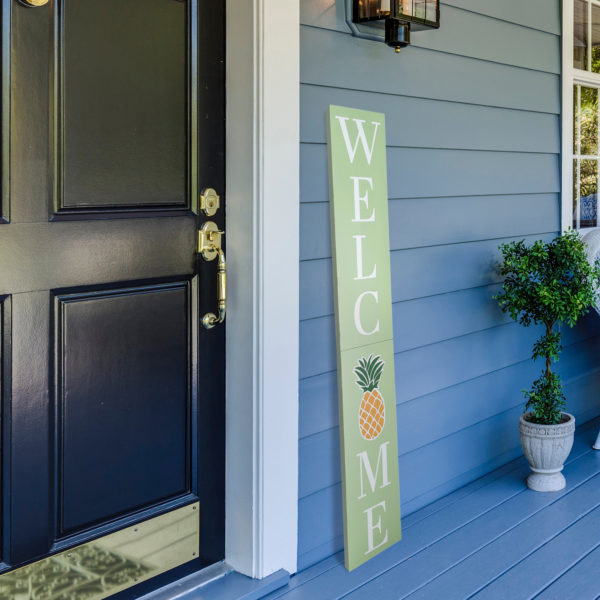 Green welcome sign on porch next to front door