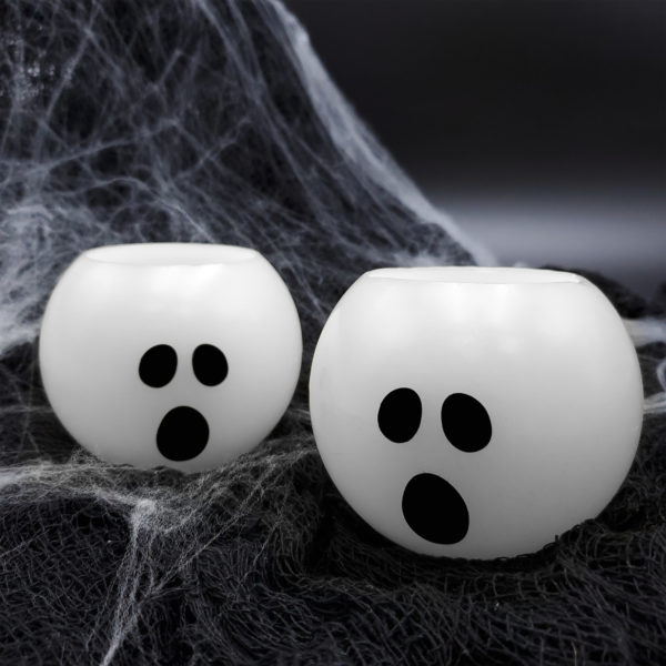 Halloween ghost candles set of 2 surrounded by spider webs and cobwebs.