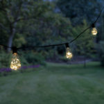 LED Edison string lights with soft white fairy lights hanging in the backyard lighting up the night.