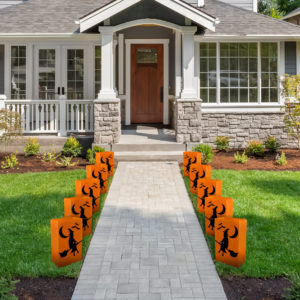 Luminaria Bags for Halloween, 12 orange plastic bags with witch design outside front of house.
